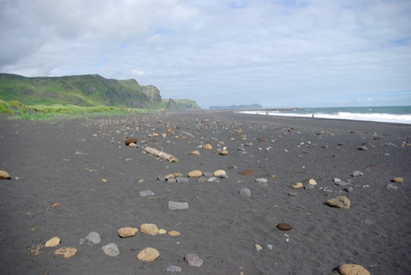 La plage de sable au noir de Vik, au pied des falaises.